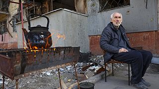 Ein Einwohner Mariupols sitzt vor einem zerstörten Gebäude