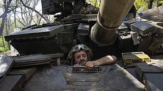 A Ukrainian serviceman enters a tank during the repair works after fighting against Russian forces in Donetsk region, 27 April 2022