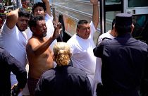الأشخاص الذين تم القبض عليهم بزعم صلاتهم بالعصابة ترافقهم الشرطة المدنية الوطنية في مركز العقوبات في سان سلفادور، 25 أبريل 2022