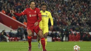 Virgil van Dijk (Liverpool, rote Spielkleidung) kommt vor Samuel Chukwueze an den Ball