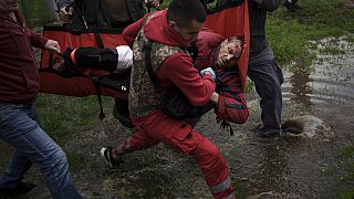 Des secouristes ukrainiens portent assistance à une victime d'un bombardement russe à Kharkiv (Ukraine), le 27/04/2022