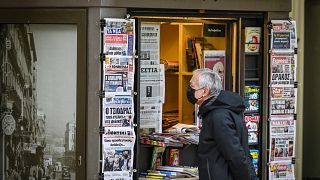 Un passant devant un kiosque à journaux en décembre 2021 à Athènes (Grèce)
