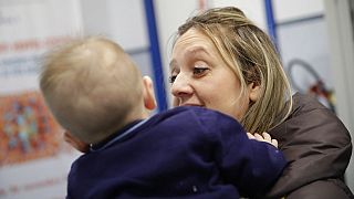 Luana Monoclesi, tient son bébé de 8 mois dans un centre de vaccination à Rome, le 23 février 2018,