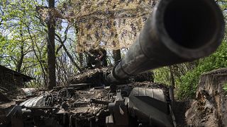 Украинский военнослужащий устанавливает пулемёт на танк в Донецкой области