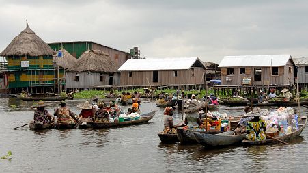 Vendors display their goods in pirogues at a floating market in Ganvie, Benin.