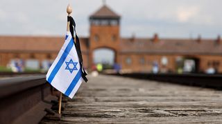 Флаг Израиля на железнодорожных путях на месте бывшего лагеря Освенцим-Биркенау во время поминовения жертв Холокоста / Польша, 28 апреля 2022 г.