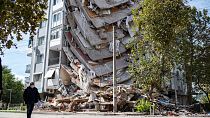 A man stands by a damaged building on November 01, 2020, in Izmir, after a powerful earthquake struck Turkey's western coast and parts of Greece.