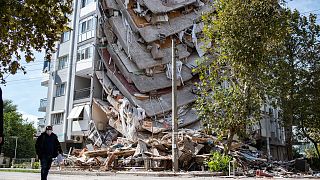 A man stands by a damaged building on November 01, 2020, in Izmir, after a powerful earthquake struck Turkey's western coast and parts of Greece.