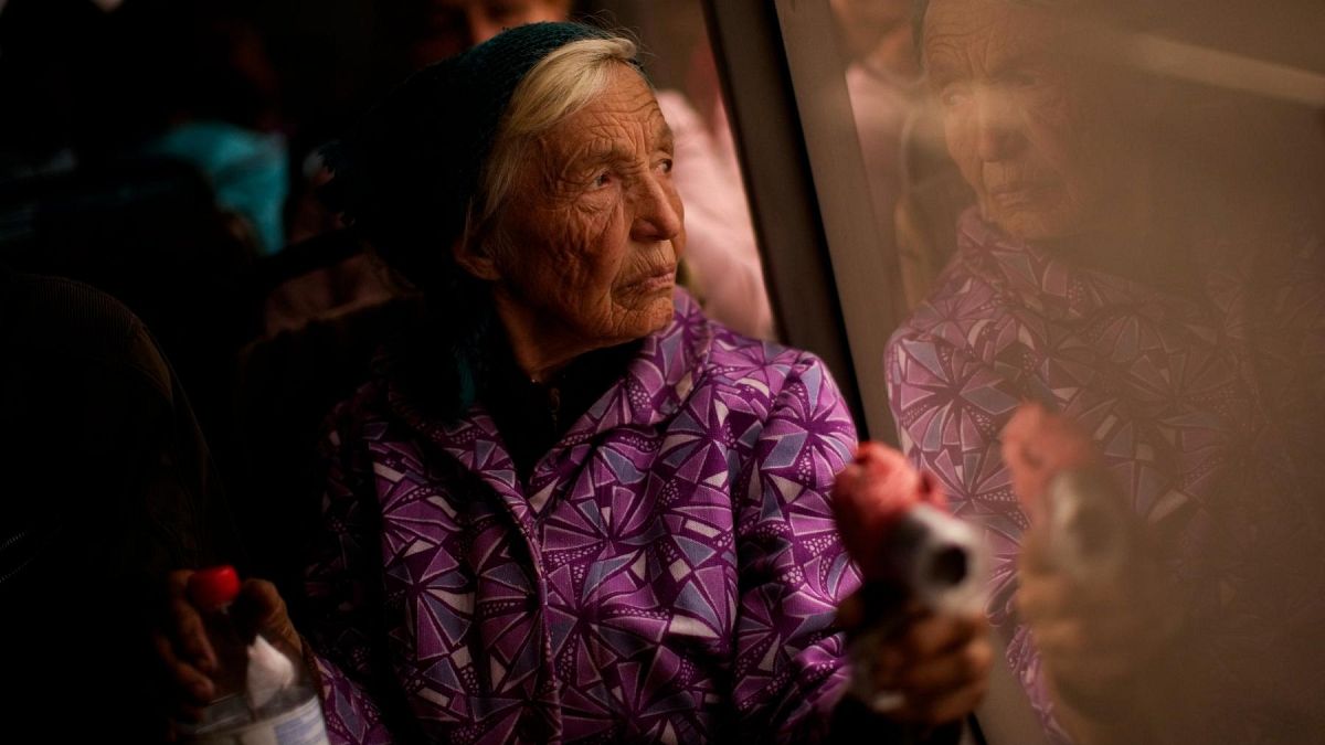 Kateryna Hodza, 85, takes a bus from a reception center for displaced people in Zaporizhzhia, Ukraine, Friday, April 29, 2022. 