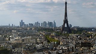 This photograph taken in Paris on April 22, 2022 shows the Eiffel Tower with La Defense business district in the background. 