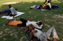 Des personnes se reposent à l'ombre d'un arbre dans l'État d'Uttar Pradesh, en Inde,