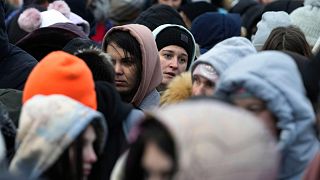 Refugees from Ukraine wait in a crowd for transportation after fleeing their homeland and arriving at the border crossing in Medyka, Poland, Monday, 7 March, 2022