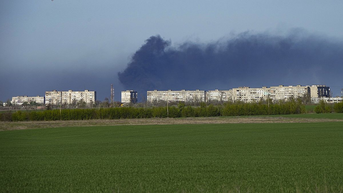 In der Ferne steigt über dem umkämpften Stahlwerk in Mariupol Rauch auf.
