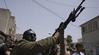 مقاتل فلسطيني ملثم يطلق النار في الهواء خلال جنازة يحيى عدوان في قرية عزون بالضفة الغربية، بالقرب من قلقيلية. 2022/04/30