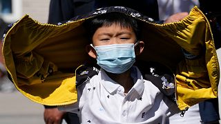 A child wearing a mask lines up for COVID test on Sunday, May 1, 2022, in Beijing.