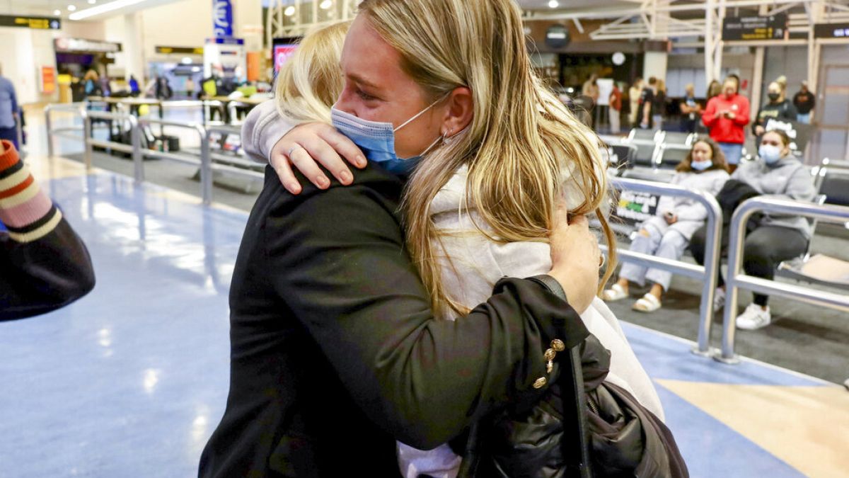 Οικογένειες αγκαλιάζονται μετά από πτήση από το Λος Άντζελες που έφτασε στο διεθνές αεροδρόμιο του Όκλαντ
