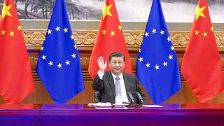 Chinese President Xi Jinping waves during a video conference with European leaders from Beijing on Wednesday, Dec. 30, 2020.