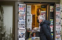A passer-by in front of a newspaper kiosk in December 2021 in Athens, Greece