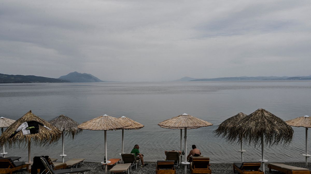 أشخاص يجلسون في أحد المطاعم الشاطئية في جزيرة إيفيا اليونانية