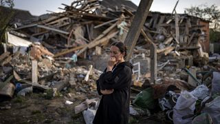 Woman surveys wreckage of her home in Irpin, near Kyiv in Ukraine
