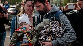A man welcomes Anna Zaitseva and her son Svyatoslav, 6 month old, after arriving from Mariupol at a reception centre in Zaporizhzhia on May 3, 2022.