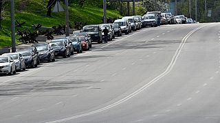 Cars queuing at the exit of the road to a petrol station.