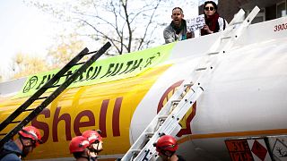 Police officers try to remove Etienne Stott, former Olympian, and an activist from Extinction Rebellion who have occupied a Shell oil tanker during a protest.