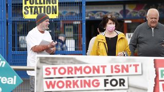 Избирательный участок в населённом преимущественно католиками Западном Белфасте и плакат с надписью "Парламент не работает в интересах нашего района", 5 мая 2022 года