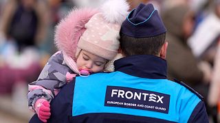 A Frontex European border police officer carry a child as refugees arrive from Ukraine at the border crossing Vysne Nemecke, Slovakia, March 1, 2022.