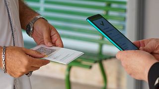 A teacher has his "Green Pass" checked by a school worker as he arrives at the "Isacco Newton" high school, in Rome, on Sept. 13, 2021.