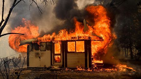 Flames from the Morton Fire consume a home near Bundanoon, Australia in 2020.