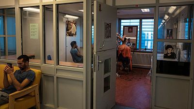 پناهجویان ایرانی در حال اصلاح موی سر یکدیگر در اردوگاه پناهندگان در هلند