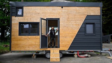 Pascal, 52, formely homeless, poses in the "tiny house" he built with other homeless people, in the premises of Amisep, a Breton association fighting against precariousness.