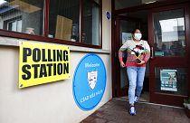 Une femme quitte un bureau de vote après avoir voté à Clonoe, en Irlande du Nord, jeudi 5 mai 2022.