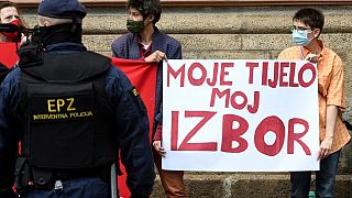 A police officer stands guard in front of women's rights activists during an anti-abortion march in Zagreb in May 2021.