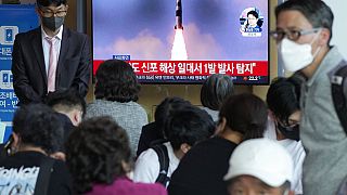 People watch a TV showing a file image of North Korea's missile launch during a news program at the Seoul Railway Station in Seoul, South Korea, Saturday, May 7, 2022