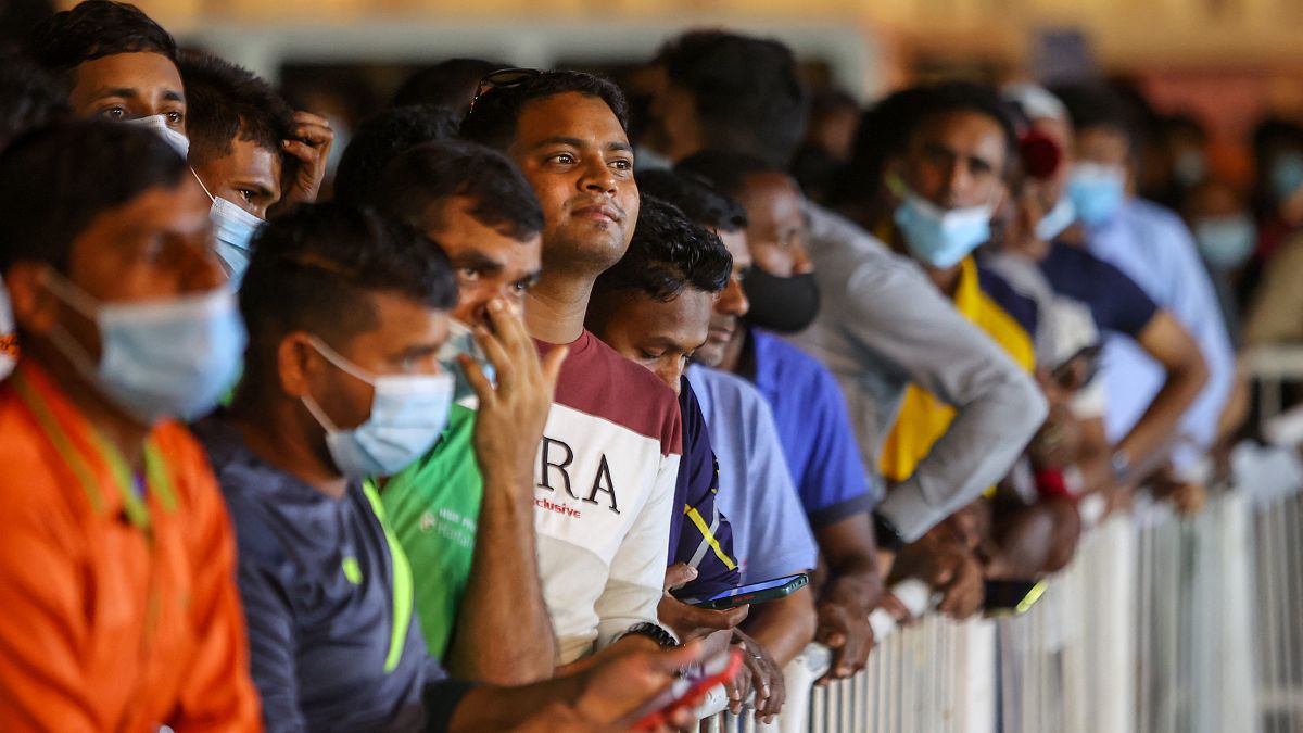 آلاف من العمال المهاجرين يقفون في طوابير طويلة لمشاهدة كأس العالم لكرة القدم المعروض في الدوحة