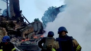 Emergency crew tend to a fire near a burning debris, after a school building was hit as a result of shelling, in the village of Bilohorivka, Luhansk, Ukraine, May 8, 2022