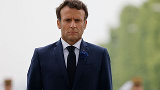 French President Emmanuel Macron stands in front of a wreath of flowers at the Tomb of the Unknown soldier in Paris, Sunday 8 May 2022