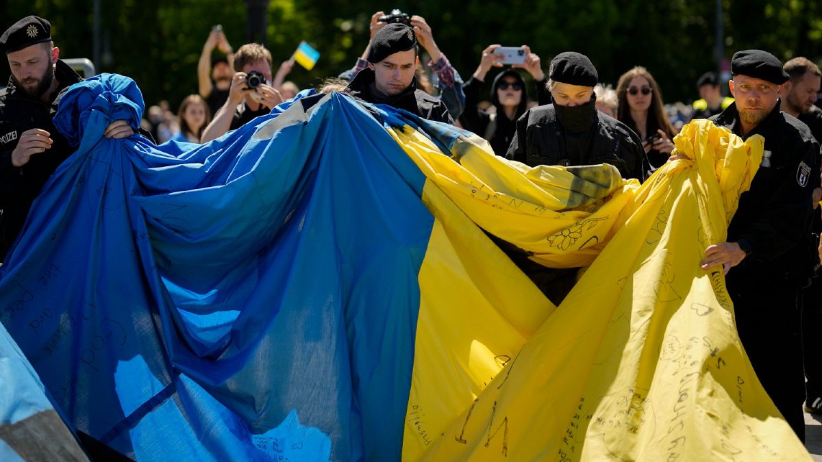German police remove a huge Ukrainian flag from a Soviet War Memorial in Berlin on Sunday during commemorations to celebrate the end of World War II.
