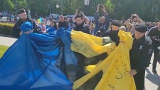 Policías alemanes retiran una bandera ucraniana de la manifestación.