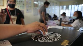 موظف في لجنة الانتخابات يضع إيصال التصويت داخل صندوق في أحد مراكز الاقتراع يوم الاثنين 9 مايو 2022 في مدينة كويزون بالفلبين لانتخاب رئيس للبلاد