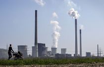 A mother pushes a stroller in front of the Scholven coal fired power station, owned by Uniper, in Gelsenkirchen, Germany.