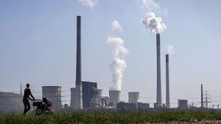 A mother pushes a stroller in front of the Scholven coal fired power station, owned by Uniper, in Gelsenkirchen, Germany.