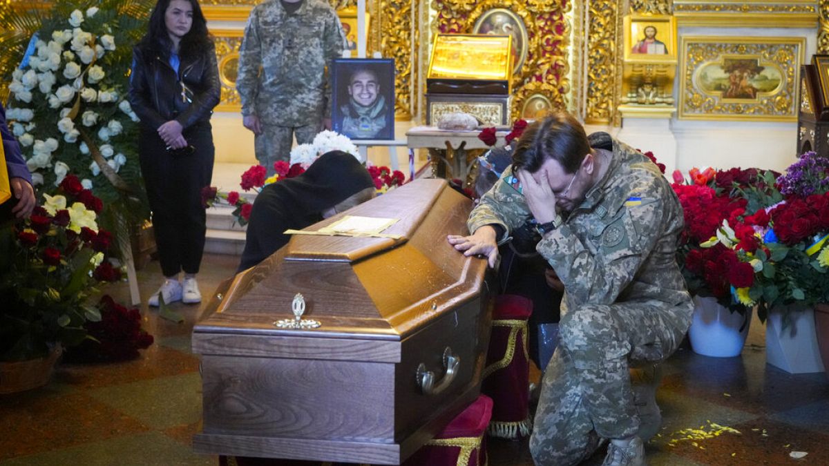 Un soldat prête un dernier hommage à Oleksandr Makhov, 36 ans journaliste ukrainien engagé comme soldat volontaire, tué au front.