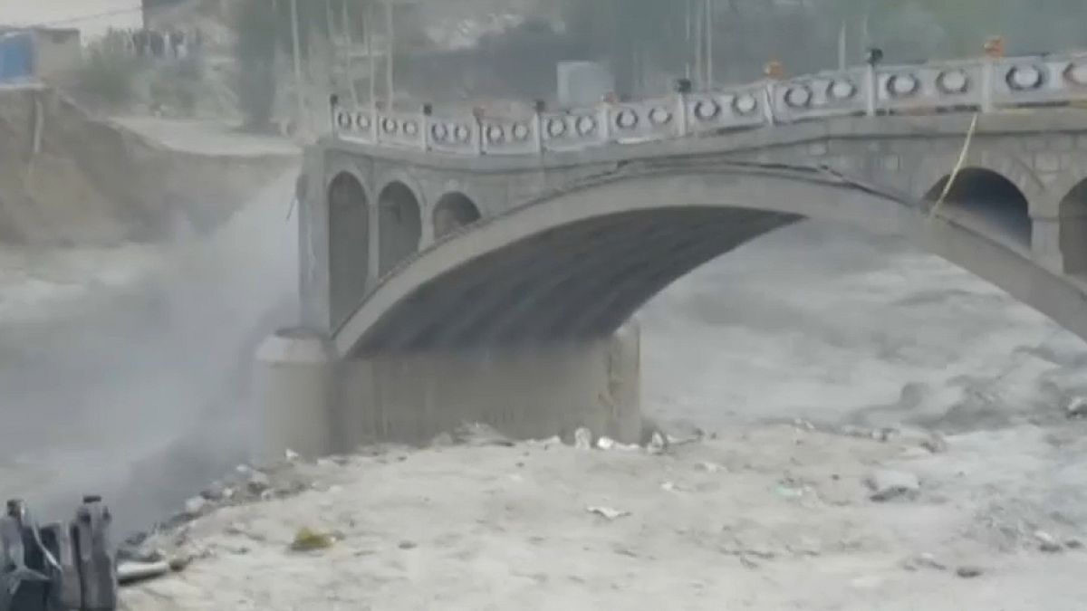Wide shot bridge starting to collapse in the Hunza vally due to flash flooding.
