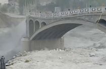 Wide shot bridge starting to collapse in the Hunza vally due to flash flooding.