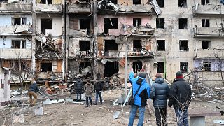 Buildings in Kyiv's suburbs were hit by military fire on February 24, hours after a cyber attack disrupted internet connections in Ukraine