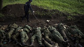 Ein ukrainischer Soldat sucht Sprengfallen an Leichen russischer Soldaten nahe Charkiw
