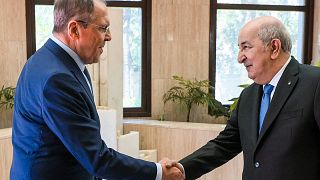 وزير الخارجية الروسي سيرغي لافروف (إلى اليسار) وهو يصافح الرئيس الجزائري عبد المجيد تبون خلال اجتماعهما في الجزائر العاصمة في 10 مايو / أيار 2022.